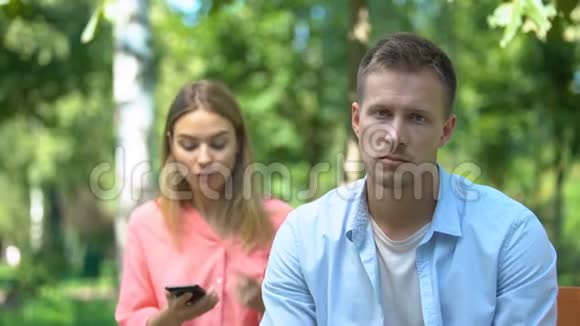 嫉妒的女人和男朋友吵架在他的手机上看私人信息视频的预览图