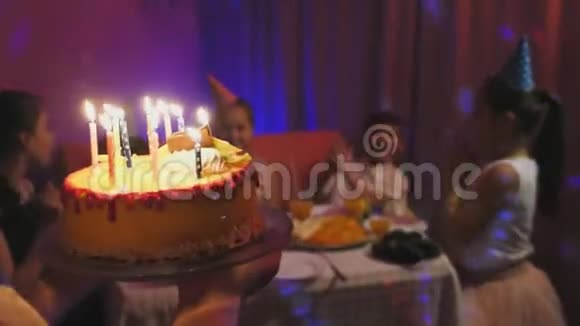 妈妈拿着美味的蛋糕和燃烧的五彩蜡烛视频的预览图