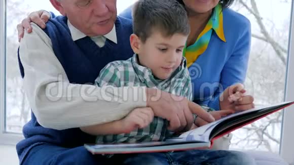 家庭教育带着祖父母的孩子休闲看书视频的预览图