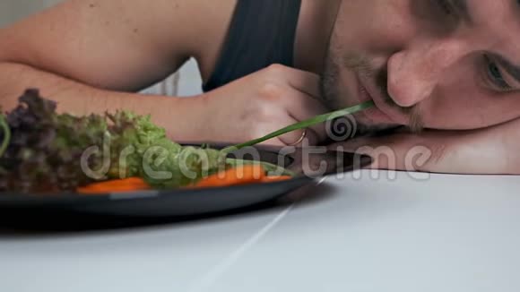 一个秃顶的素食主义者厌恶地吃沙拉适当营养健康生活方式视频的预览图