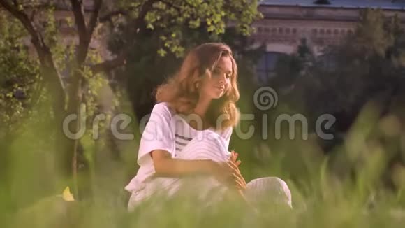 公园里一个年轻的白种人浅黑肤色的女孩坐在草地上浑身是灰在思考视频的预览图