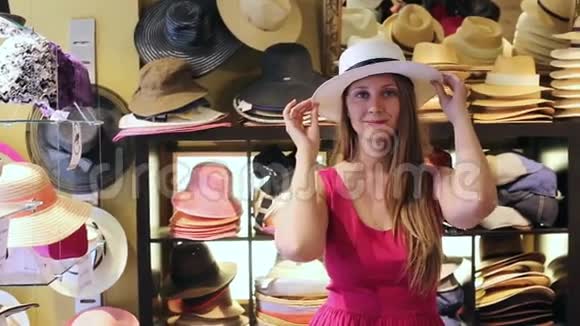 年轻快乐的金发女人在商店里选择草帽视频的预览图