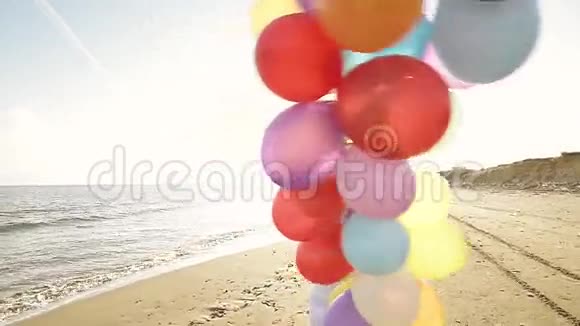 可爱的女孩在海滩上玩气球视频的预览图