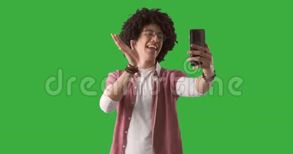 男子使用手机进行绿色背景视频通话视频的预览图
