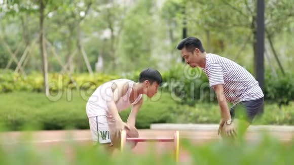 早上亚洲父子在花园里慢动作打篮球视频的预览图