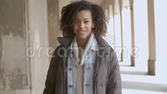 年轻美丽的混血女人带着非洲发型走路的肖像视频的预览图
