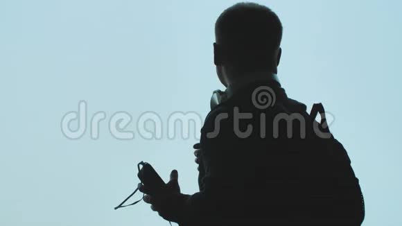 一个年轻人打开智能手机上的音乐在飞机起飞的背景下戴上耳机视频的预览图