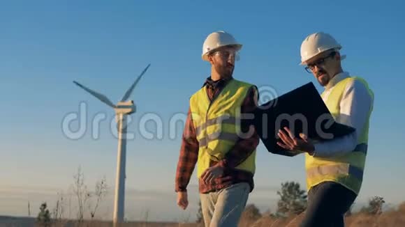 男人在实地检查风力涡轮机时讨论一个项目环境能源概念视频的预览图