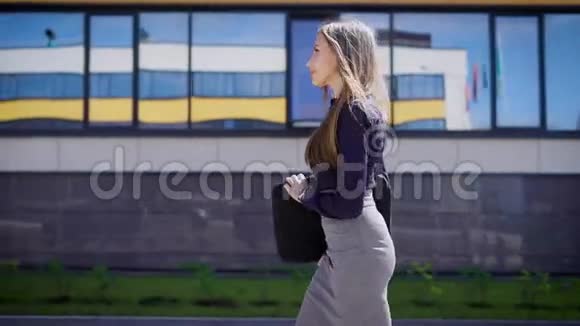 自信的女商人在办公室散步自信的年轻女企业家在办公楼散步的侧视视频的预览图