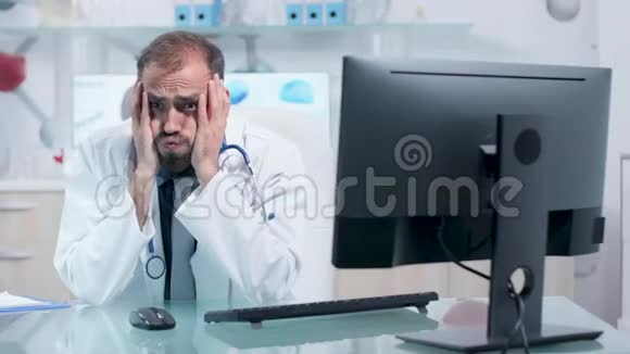 在他的现代办公室工作过度的医生或医生视频的预览图