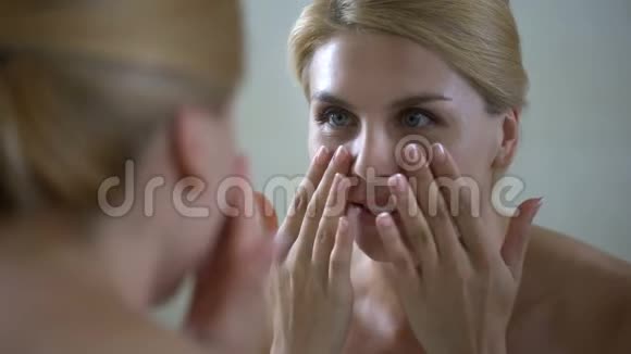 美容师访问后对面部状况满意的中年妇女视频的预览图
