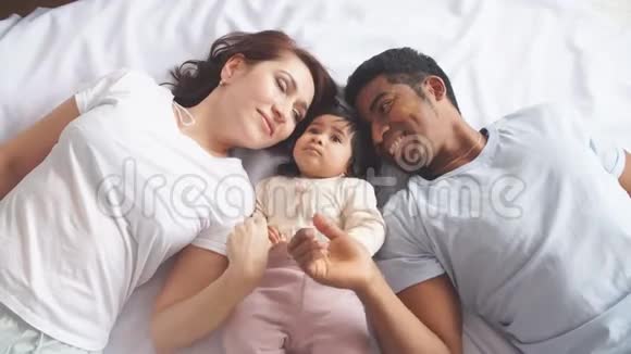 快乐的父母和可爱的女婴在家睡觉视频的预览图