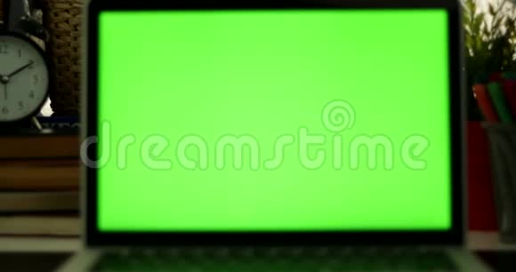 多莉出了带绿色屏幕的笔记本电脑黑暗的办公室完美地放置你自己的图像或视频正在使用的技术绿色屏幕视频的预览图