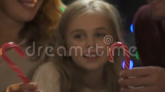快乐的父母从糖果拐杖形成了心灵闪闪发光的圣诞装饰视频的预览图