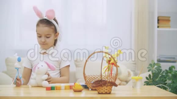 小可爱可爱的女孩正微笑着手里拿着复活节兔子玩概念复活节假期视频的预览图