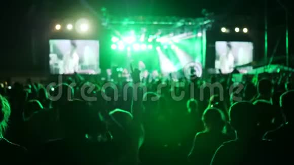人群在摇滚音乐节上跳着舞舞台上明亮的灯光举起扇子兴奋的观众挥舞着手视频的预览图