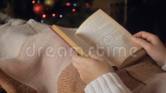 拍摄女性阅读书籍和在沙发上喝茶的慢镜头以及点亮圣诞树视频的预览图