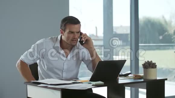 商人在家里用手机大喊大叫愤怒的男人在电话里尖叫视频的预览图