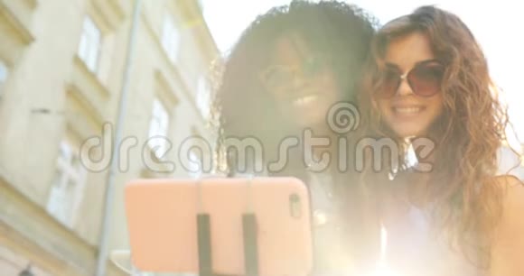 两个迷人的微笑女孩在自拍的同时发送空气吻的特写肖像其中一个是美国黑人视频的预览图