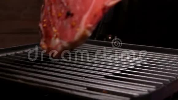 厨师用钳子把牛排放在烤架上视频的预览图