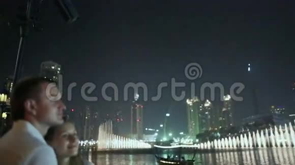 情侣在夜城喷泉的背景下互相欣赏视频的预览图