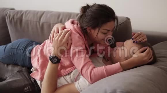 年轻夫妇放松拥抱时躺在沙发上的客厅与阁楼内部可爱的女孩躺在床上视频的预览图