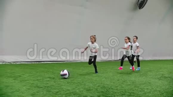 室内足球场小孩子在踢足球在足球场上奔跑视频的预览图