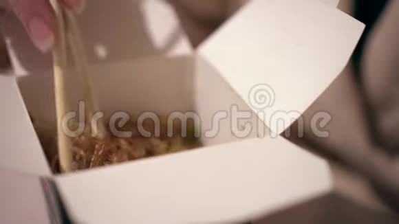 女性用筷子从盒子里拿出面条视频的预览图