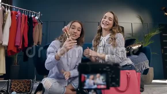 两位女性时尚博主在vlog上录制化妆教程分享社交媒体视频的预览图