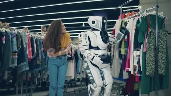 漂亮的女士在机器人的帮助挑选衣服视频的预览图