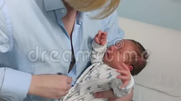 妈妈母乳喂养拥抱宝宝年轻的母亲在家里的蓝白色房间里喂她的婴儿妈妈视频的预览图