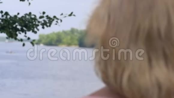 快乐微笑的老妇人在大自然中放松看着湖闭上眼睛视频的预览图