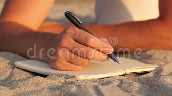 在海滩上写日记的人视频的预览图