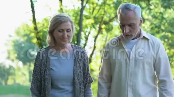 退休夫妇在公园散步男性养老金领取者患有心脏病视频的预览图