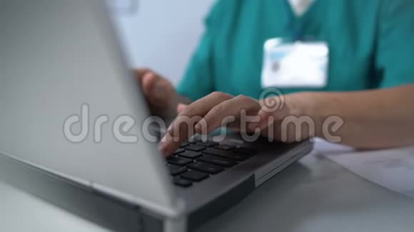 护士在笔记本电脑上打字在线完成医疗文件咨询视频的预览图