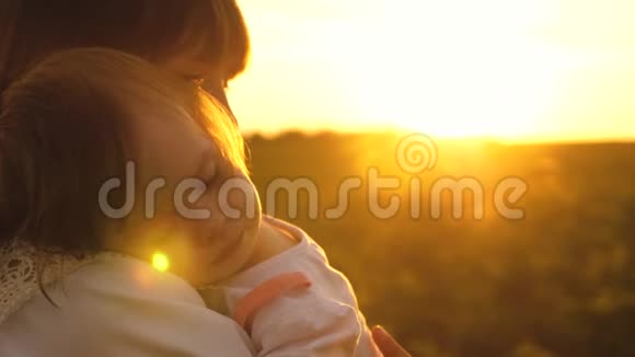 小孩子抱着妈妈睡着了夏天在公园里夕阳西下慢悠悠地走着妈妈和女儿视频的预览图