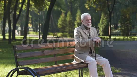 孤独的老人心烦意乱独自坐在公园里思考生活养老金领取者视频的预览图