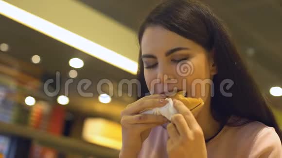 吃快餐的女士在餐馆吃汉堡包饥饿的学生小吃视频的预览图