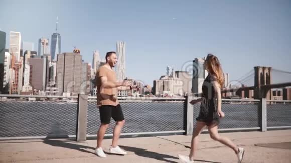 快乐的白种人男人会见他的女朋友拥抱和微笑在阳光明媚的曼哈顿天际线在纽约市慢动作视频的预览图