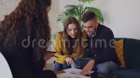 爱的男朋友和女朋友正在看他们要买的房子的计划并与房地产经纪人交谈视频的预览图