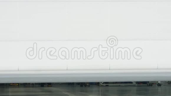 机库背景下的卷帘门和平面商务喷气式飞机在机库里私人公司的飞机停在视频的预览图