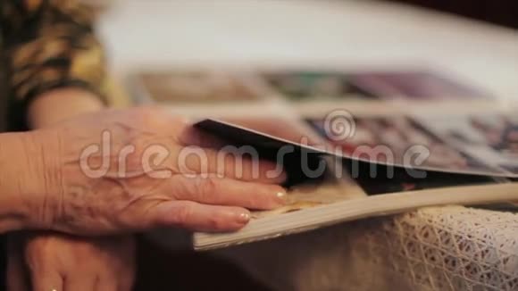 老女人看旧相册里的照片回忆倾斜视频的预览图