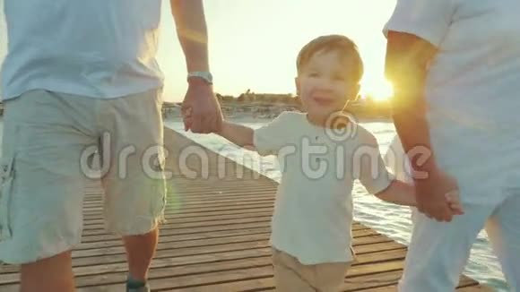 快乐男孩和祖父母一起沿着码头散步视频的预览图