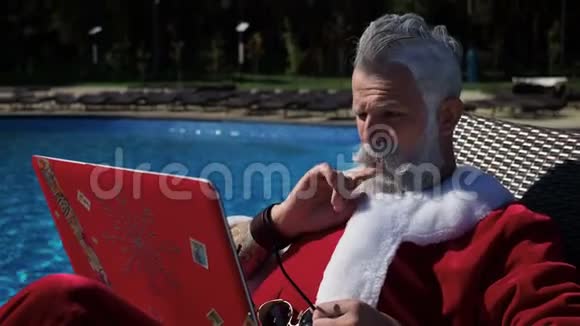 圣诞老人在游泳池里放松用手提电脑开疯狂的玩笑视频的预览图