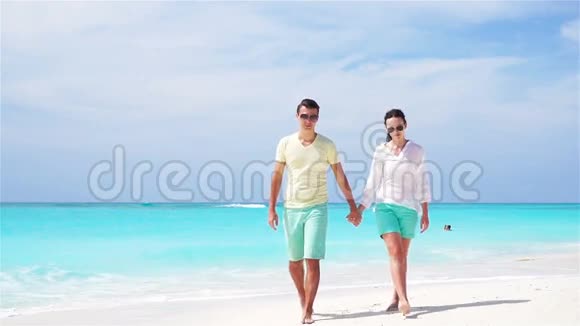 暑假期间在白色海滩上的年轻夫妇幸福的家庭享受他们的蜜月流动视频视频的预览图