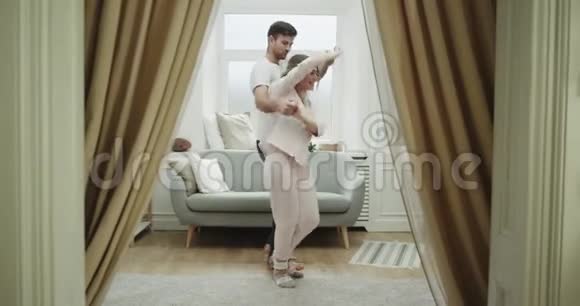 客厅里舒适的气氛情侣们穿着睡衣跳舞浪漫4k视频的预览图
