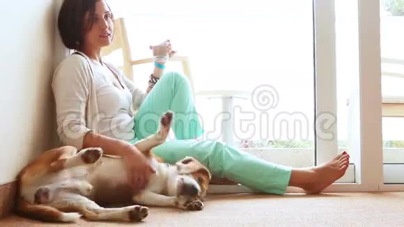 快乐的母子一家人在家的地板上和友好的比格犬视频的预览图