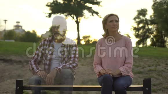沮丧的老妇人坐在长凳上丈夫出现在旁边失落回忆视频的预览图