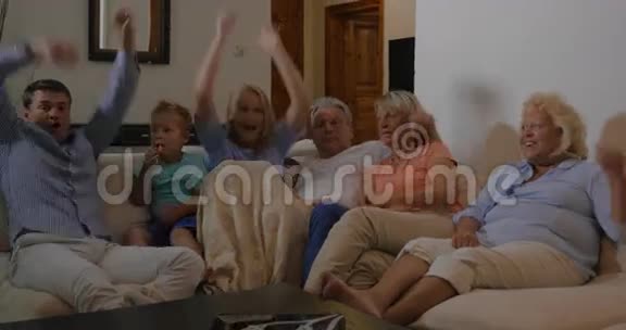 家庭在电视上观看体育赛事对胜利感到高兴视频的预览图