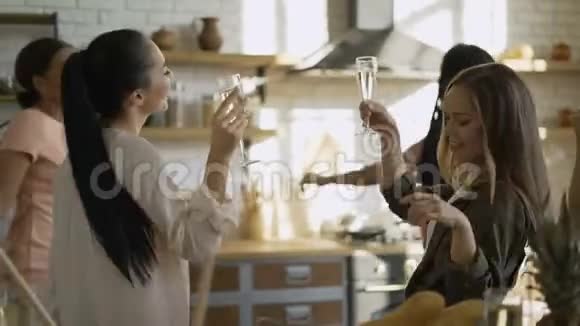 混合种族的5个女朋友在厨房里玩得很开心女孩喝香槟跳舞视频的预览图